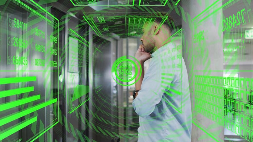 An IT professional thoughtfully analyzing green digital data overlays in a server room, illustrating the "Green VM" illusion where infrastructure metrics display a healthy green status during disaster recovery while application-level validation remains underway.