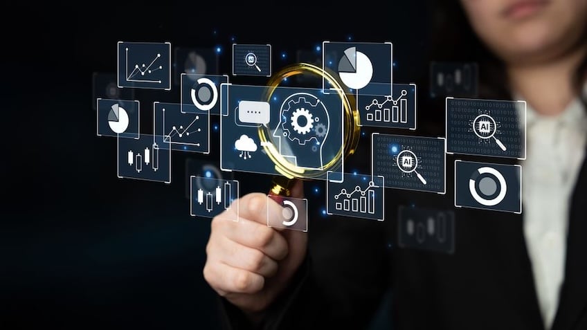 Business professional examining floating digital analytics dashboards and an AI gear icon with a magnifying glass, representing predictive workload observability and conversational AI analytics.